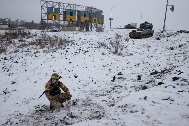 Soldados ucranianos mantienen una posición junto a la señalización de la ciudad en una carretera a las afueras de Kharkiv, el día después de que comenzara la invasión total de Rusia, el 25 de febrero de 2022. Según un informe del New York Times, un vasto esfuerzo estadounidense de recopilación de información guió la estrategia de combate ucraniana a gran escala y canalizó información precisa sobre objetivos a los soldados sobre el terreno. (Tyler Hicks/The New York Times)