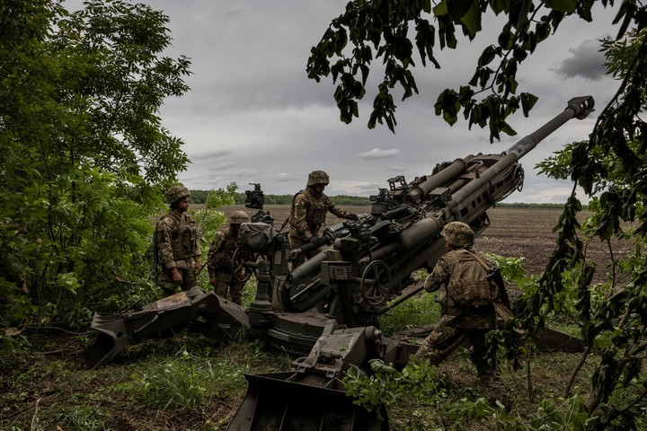 Tropas ucranianas cargan una pieza de artillería Howitzer M777 de 155 mm en la región de Donetsk, en el este de Ucrania, el 22 de mayo de 2022. La decisión de suministrar la gran artillería supuso el primer compromiso de Estados Unidos de apoyar una gran guerra terrestre. (Ivor Prickett/The New York Times)
