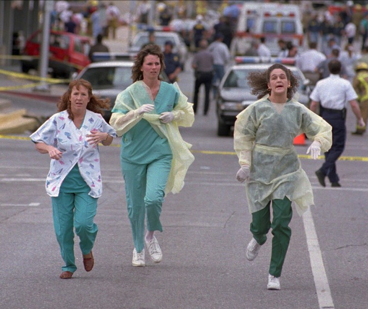 Un grupo de enfermeras corre frente al edificio federal atacado por terroristas en abril de 1995 en el centro de Oklahoma. Foto: AP  