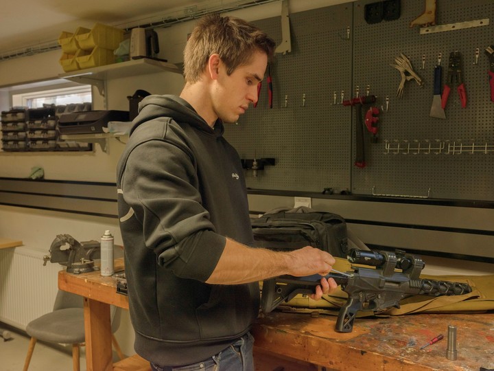 Elias Andersson en su taller con un rifle Printax que diseñó en las Islas Åland, Finlandia, en marzo de 2025. Este remoto archipiélago ofrece un ejemplo de cómo la tecnología de armas de fuego, desarrollada en Estados Unidos, se difunde entre los aficionados. (Loulou d'Aki/The New York Times)
