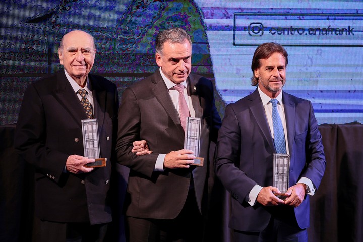 El presidente de Uruguay, Yamandú Orsi (centro), junto a los expresidentes uruguayos, Luis Lacalle Pou (izquierda) y Julio María Sanguinetti, reciben el Premio Ana Frank Latinoamérica, en el teatro San Martín en Buenos Aires. Foto: EFE/ Adán González