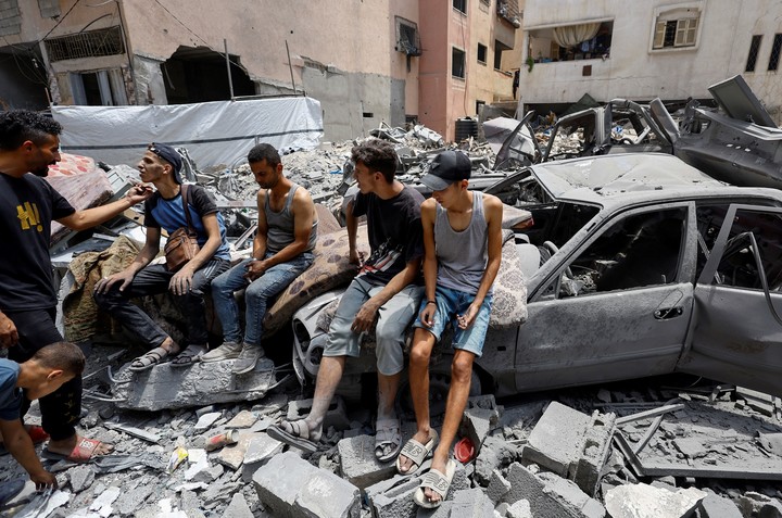 Jóvenes palestinos en medio de los escombros, tras un ataque aéreo de Israel en Ciudad de Gaza, este viernes. Foto: REUTERS