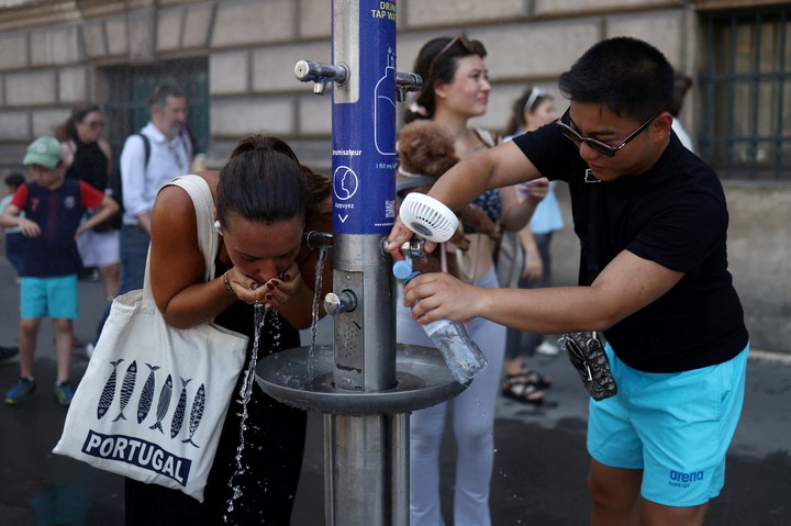 Turistas se refrescan frente a museo del Louvre, en París. Foto: REUTERS