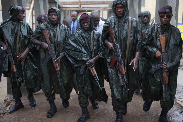 Miembros de la guardia presidencial del Congo caminan bajo una intensa lluvia delante del presidente Joseph Kabila, en 2011. Foto Reuters