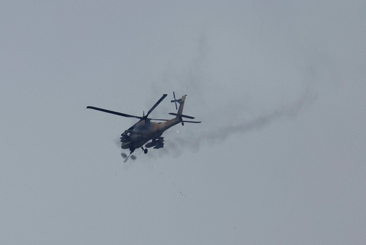 Un helicóptero Apache israelí dispara municiones mientras sobrevuela Gaza, después del anuncio de Trump. Foto: REUTERS/Ammar Awad