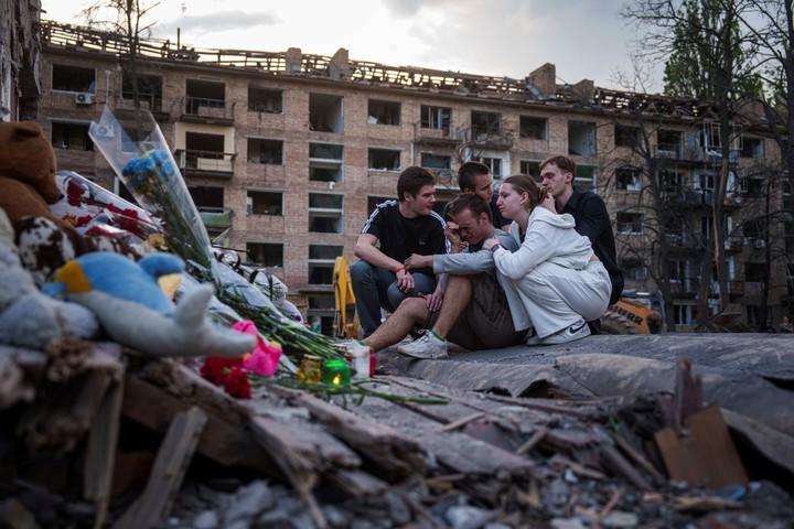 Amigos de Danylo Khudia, de 17 años, quien murió el jueves en un ataque ruso, se reúnen cerca de los escombros de una casa en un barrio residencial de Kiev, Ucrania. Foto AP