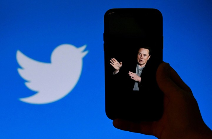 La pantalla de un teléfono muestra una foto de Elon Musk con el logotipo de Twitter al fondo. Foto AFP