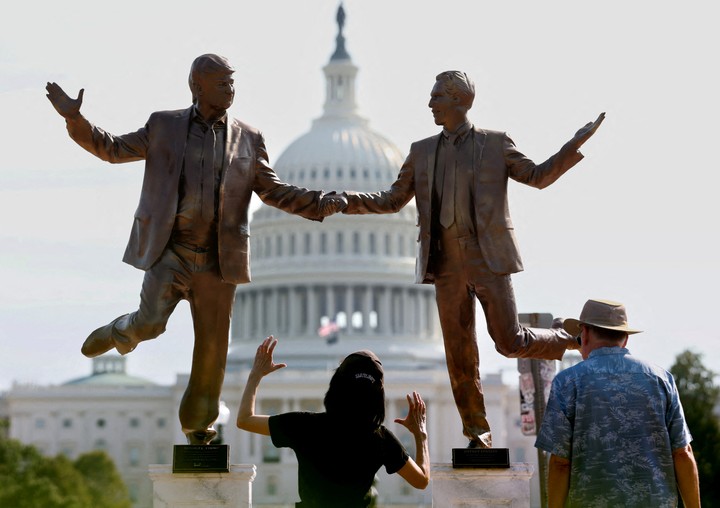 Los visitantes contemplan una estatua que representa al presidente de Estados Unidos, Donald Trump, y al financiero caído en desgracia y delincuente sexual Jeffrey Epstein bailando juntos cerca del Capitolio de Estados Unidos en Washington D. C., Estados Unidos, el 23 de septiembre de 2025. REUTERS/Kevin Lamarque/