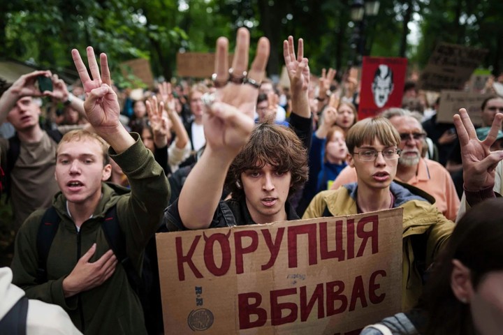 Un manifestante con un cartel que dice «La corrupción mata» y otros manifestantes frente al Parlamento ucraniano en Kiev, Ucrania, el 31 de julio. Foto Evgeniy Maloletka/Associated Press