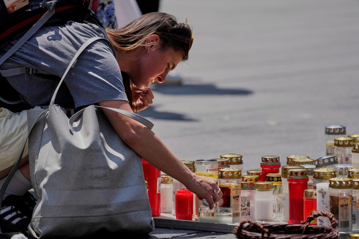 Una mujer enciende una vela en Graz. Foto: AP